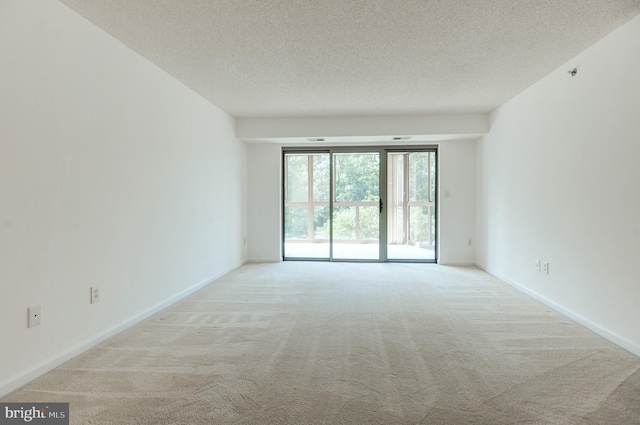 carpeted empty room with a textured ceiling