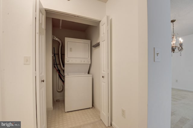 washroom with an inviting chandelier and stacked washer and clothes dryer