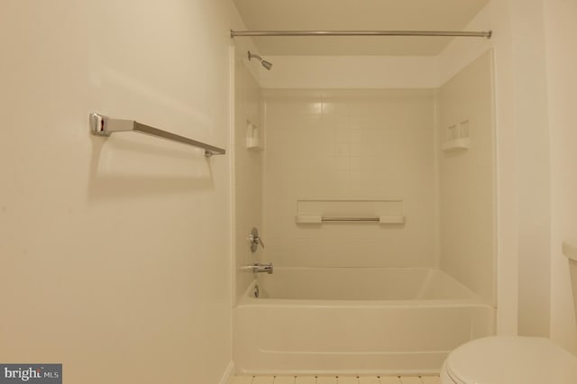 bathroom featuring toilet, tile patterned floors, and tiled shower / bath