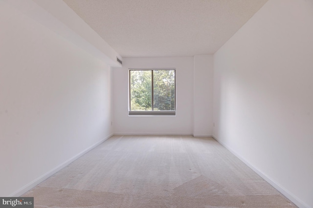 carpeted empty room with a textured ceiling