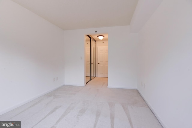 spare room featuring light colored carpet