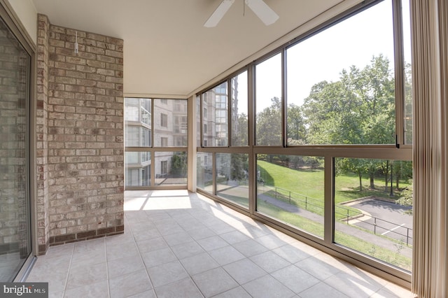 unfurnished sunroom with ceiling fan and a wealth of natural light