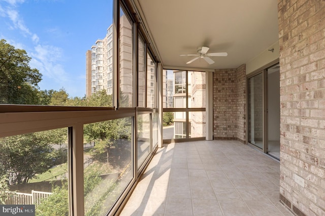 unfurnished sunroom featuring ceiling fan