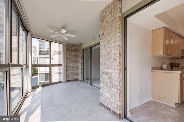 unfurnished sunroom with ceiling fan