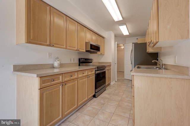 kitchen featuring light brown cabinets, stainless steel appliances, sink, and light tile patterned floors