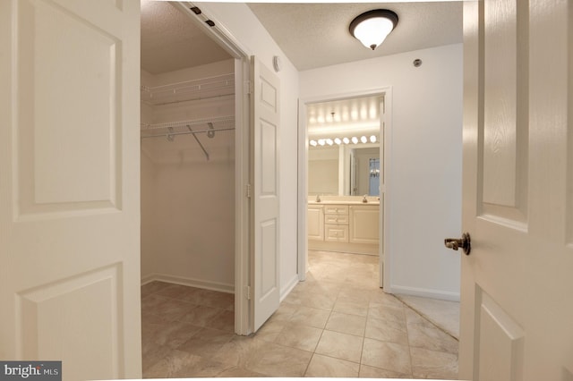 interior space with vanity, a textured ceiling, and tile patterned floors