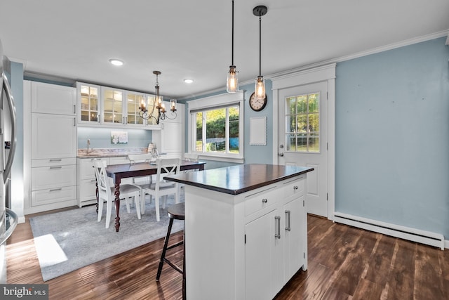 kitchen featuring white cabinetry, baseboard heating, dark wood-type flooring, and a kitchen island