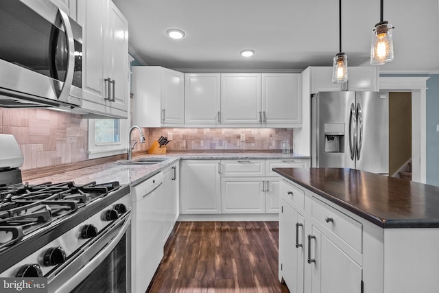 kitchen with white cabinetry, backsplash, appliances with stainless steel finishes, and sink