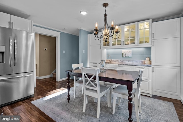 dining room featuring ornamental molding, dark hardwood / wood-style flooring, and an inviting chandelier