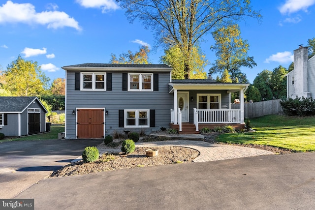 view of front of property featuring a porch, a storage unit, and a front lawn