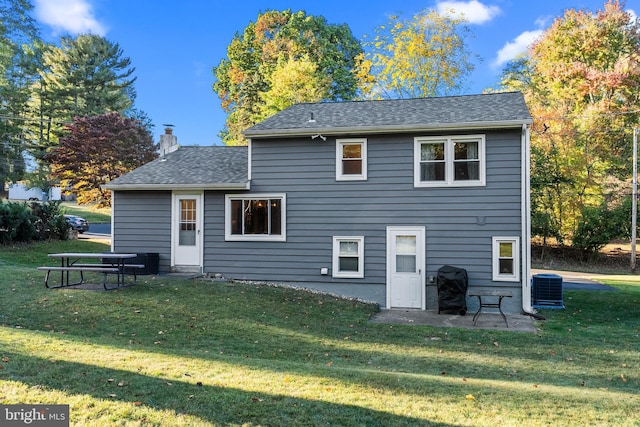 rear view of property featuring a patio area, central air condition unit, and a lawn