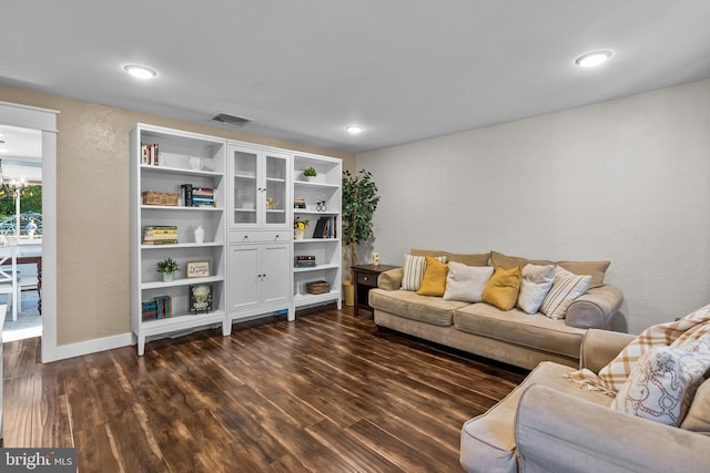 living room featuring dark hardwood / wood-style flooring and an inviting chandelier