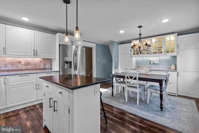 kitchen with dark hardwood / wood-style flooring, white cabinetry, a kitchen island, and stainless steel fridge with ice dispenser