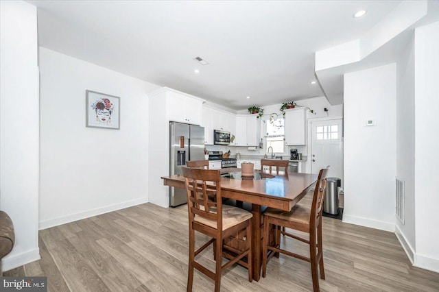 dining room with light hardwood / wood-style floors and sink