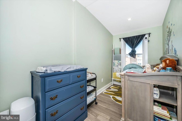 bedroom featuring light hardwood / wood-style floors and vaulted ceiling