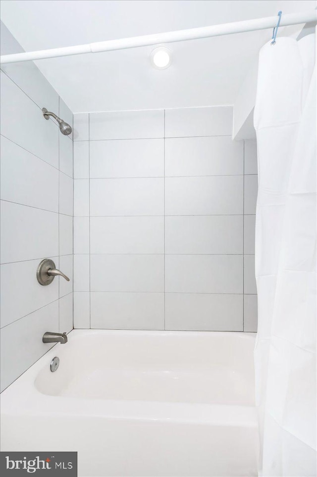 bathroom with shower / bath combo with shower curtain