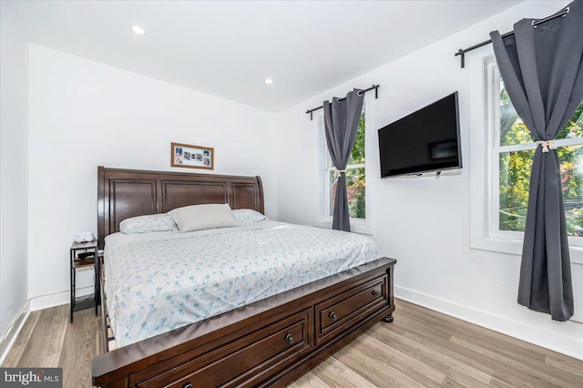 bedroom featuring light hardwood / wood-style floors and multiple windows