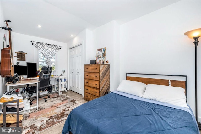 bedroom featuring vaulted ceiling, light hardwood / wood-style flooring, and a closet