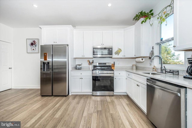 kitchen with light hardwood / wood-style flooring, white cabinets, stainless steel appliances, and sink