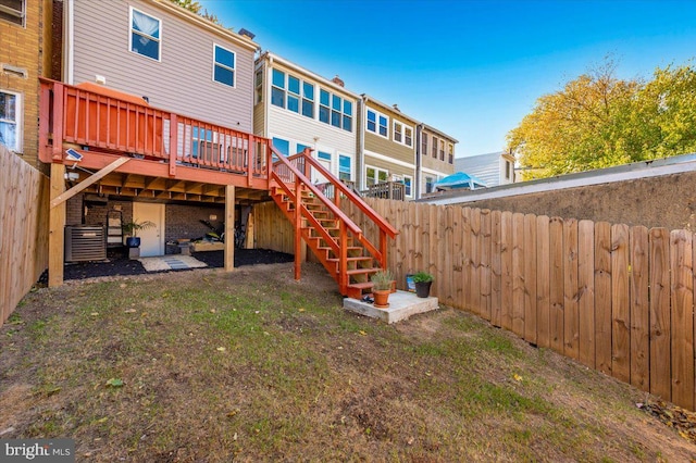 rear view of house featuring a yard, a deck, and central AC unit