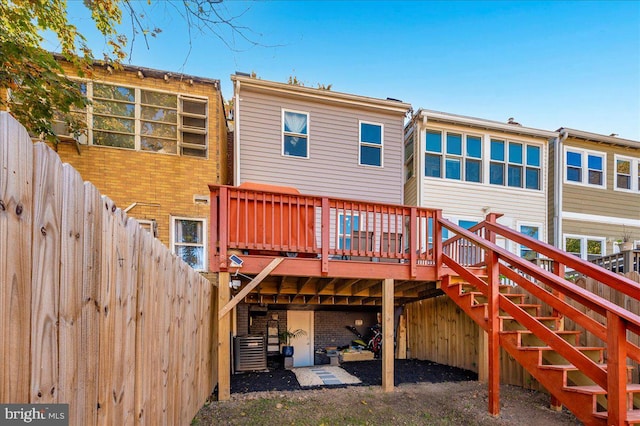 rear view of house with a wooden deck and cooling unit