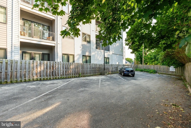 uncovered parking lot featuring fence