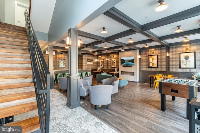 playroom featuring beam ceiling, ornate columns, wood finished floors, and coffered ceiling
