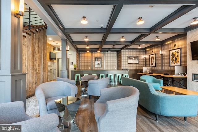 interior space with beam ceiling, wood-type flooring, coffered ceiling, and wooden walls