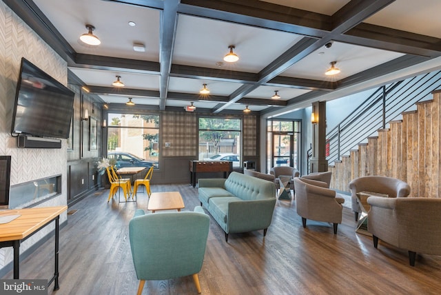 living room featuring hardwood / wood-style floors, beam ceiling, coffered ceiling, and a tile fireplace