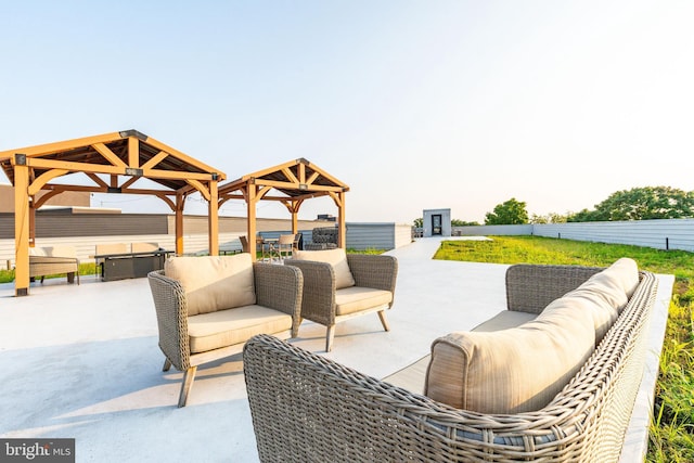 view of patio / terrace featuring fence, a gazebo, an outdoor hangout area, and a hot tub