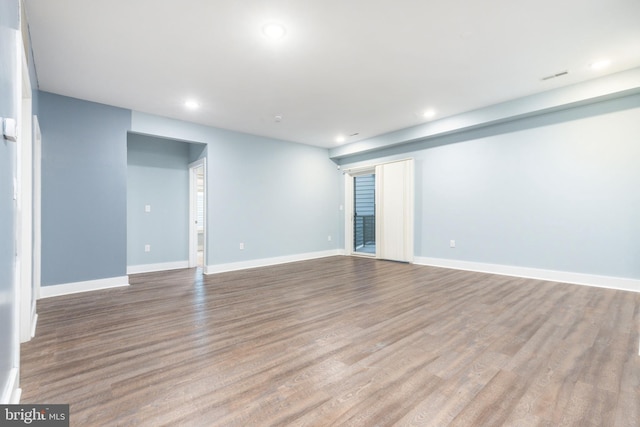 unfurnished room featuring wood finished floors, recessed lighting, and baseboards