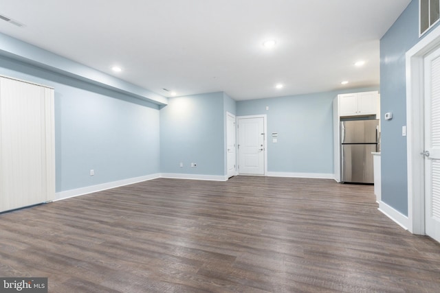unfurnished living room with dark wood-type flooring, recessed lighting, visible vents, and baseboards