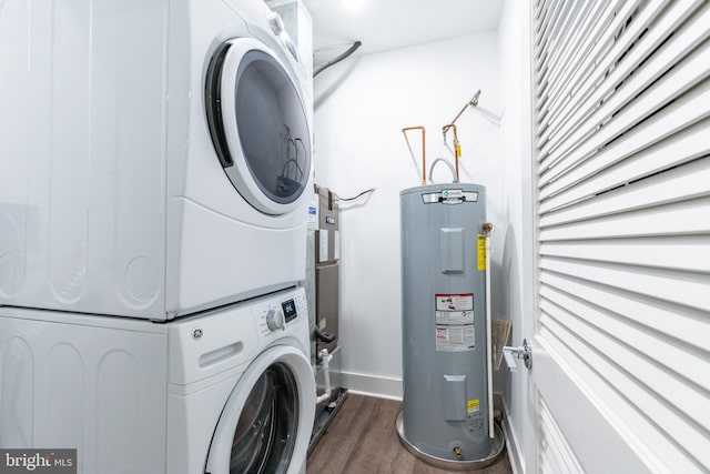 clothes washing area featuring electric water heater, stacked washer and clothes dryer, and dark hardwood / wood-style flooring