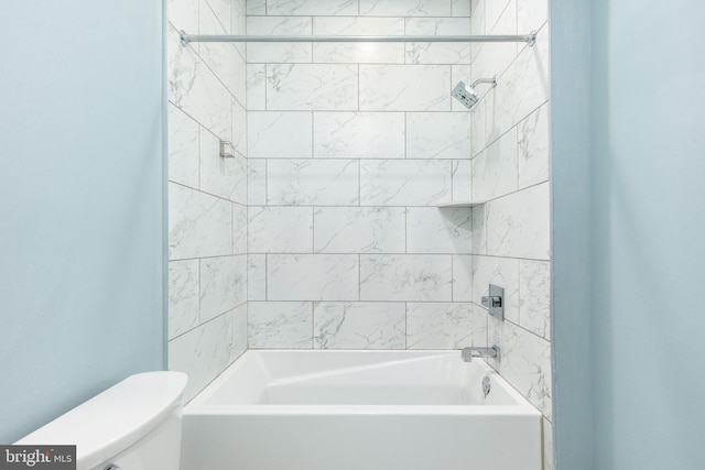 bathroom featuring tiled shower / bath and toilet