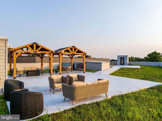 patio terrace at dusk featuring a gazebo, an outdoor hangout area, and a yard