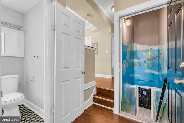 bathroom featuring wood-type flooring, toilet, and ornamental molding