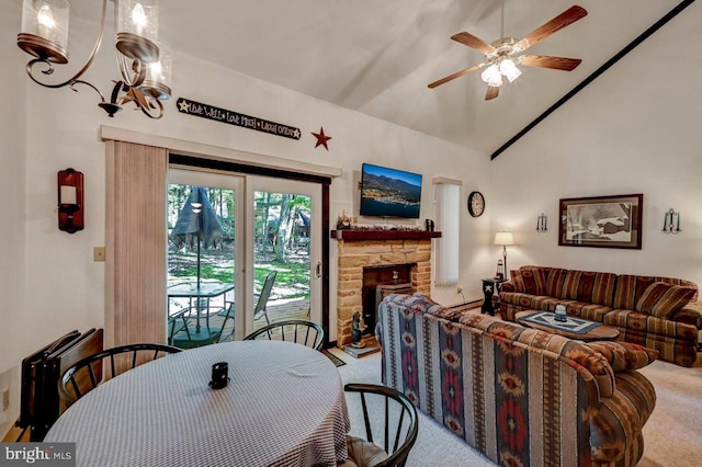 carpeted dining area featuring lofted ceiling, a fireplace, and ceiling fan with notable chandelier