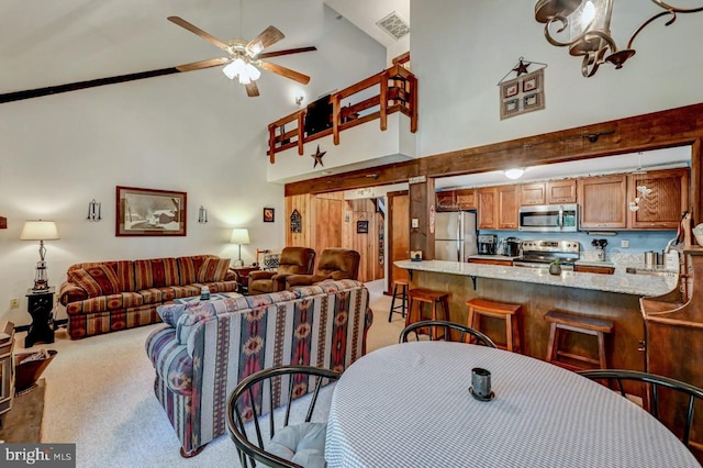 dining room featuring ceiling fan, high vaulted ceiling, and light colored carpet