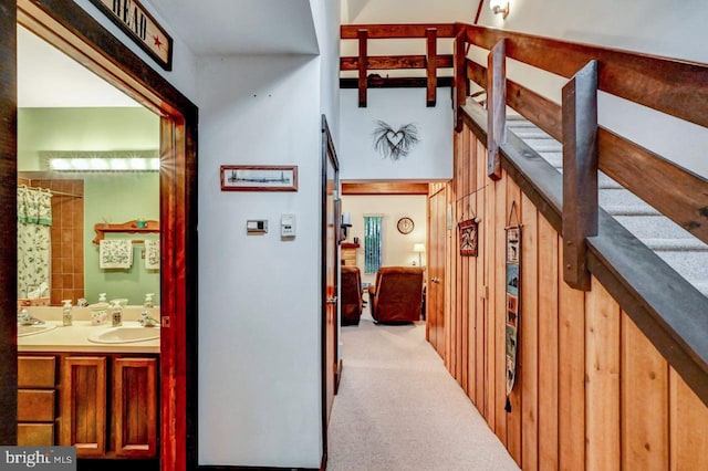 hallway featuring light colored carpet and sink