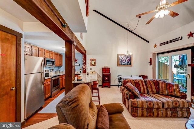 living room with beam ceiling, high vaulted ceiling, ceiling fan with notable chandelier, and light wood-type flooring