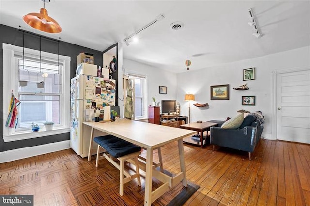 kitchen featuring hardwood / wood-style floors, track lighting, white fridge, and a healthy amount of sunlight