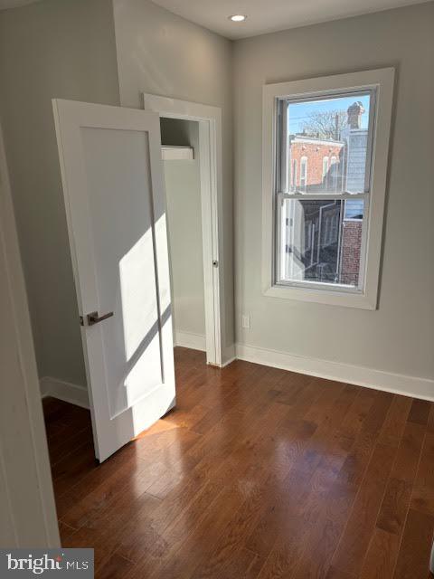 unfurnished room with dark hardwood / wood-style flooring