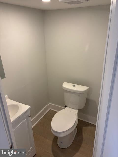 bathroom featuring toilet, wood-type flooring, and vanity