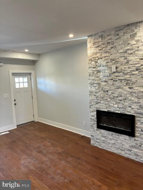 unfurnished living room featuring dark hardwood / wood-style flooring and a fireplace