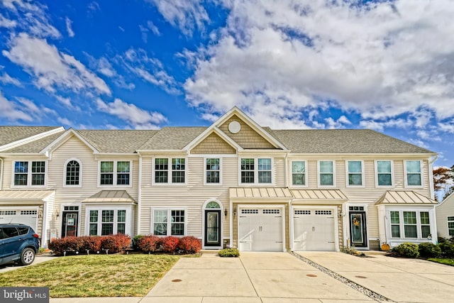 townhome / multi-family property featuring a front yard and a garage