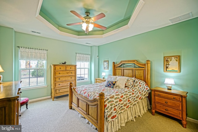 carpeted bedroom featuring a tray ceiling and ceiling fan