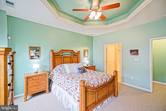 bedroom with light colored carpet, ceiling fan, and a tray ceiling