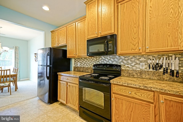 kitchen featuring black appliances, a notable chandelier, backsplash, light stone countertops, and light carpet