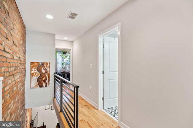 hallway featuring visible vents, an upstairs landing, light wood-style flooring, recessed lighting, and baseboards