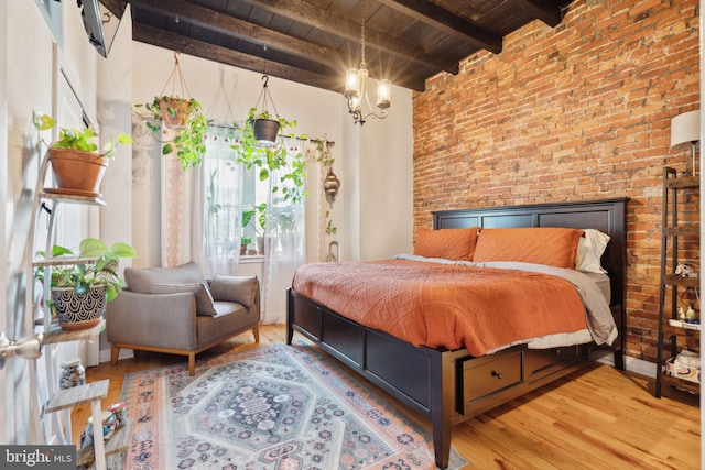 bedroom with brick wall, a chandelier, wood ceiling, beam ceiling, and wood finished floors